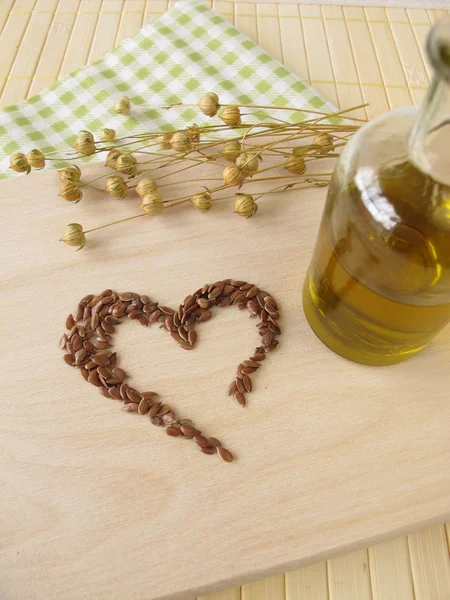 Serce z siemienia lnianego i butelka oleju lnianego — Zdjęcie stockowe