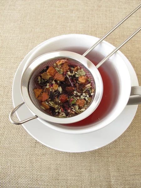 Té de hierbas con frutas y flores en colador de té — Foto de Stock