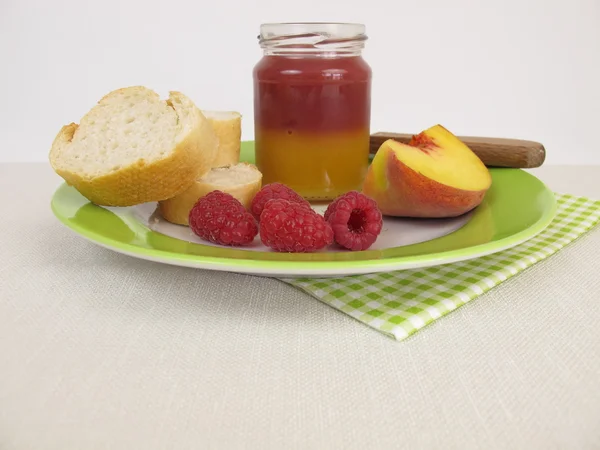 Petit déjeuner avec pêche bicolore et confiture de framboises — Photo