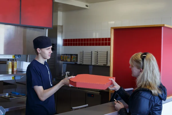 Man handing over a pizza — Stock Photo, Image