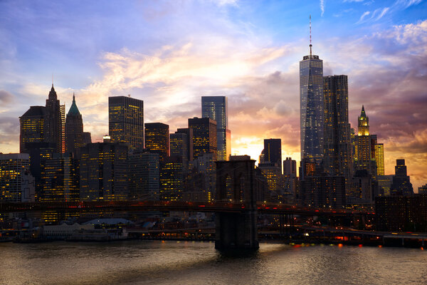 Manhattan skyline with Brooklyn Bridge at sunset, New York