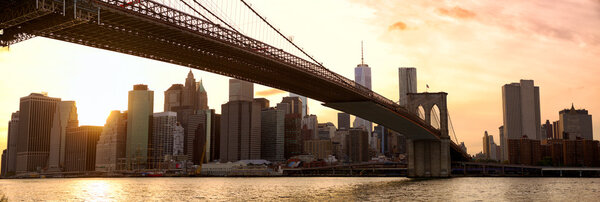 Manhattan skyline panorama and Brooklyn Bridge at sunset, New York City
