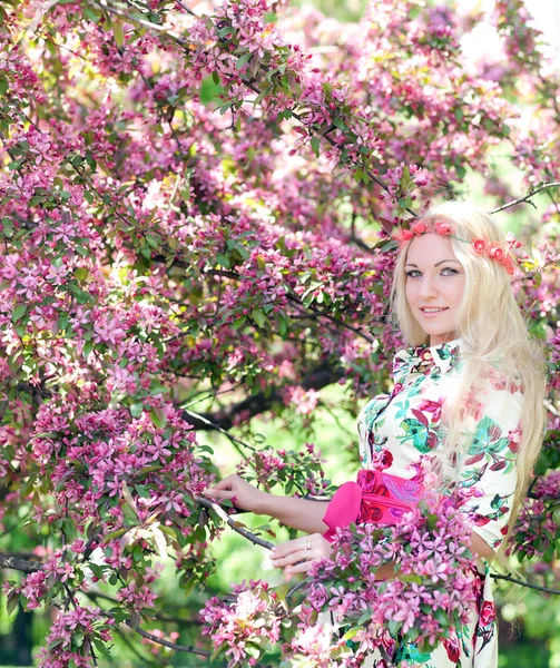 Mujer cerca del manzano floreciente — Foto de Stock