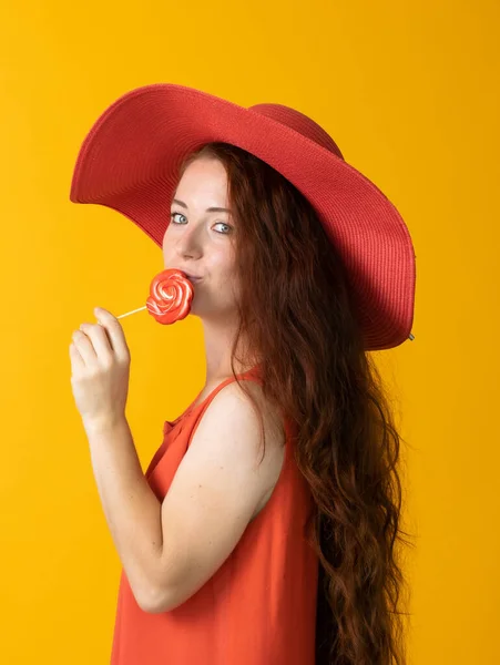 Beautiful Woman Long Hair Big Red Hat Lollipop Yellow Background — Stock Photo, Image