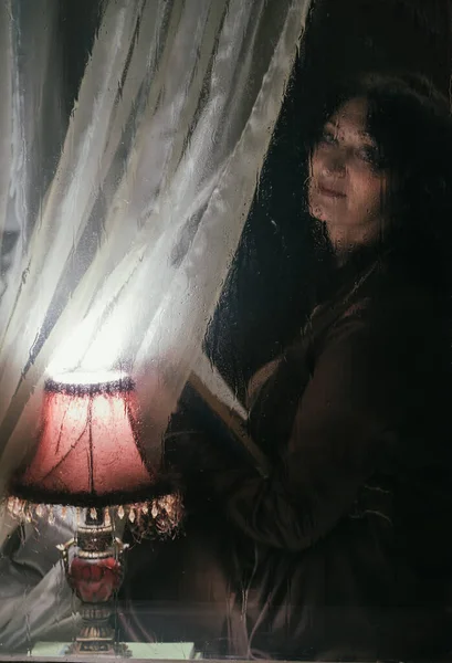 Hermosa Mujer Con Libro Bajo Luz Una Lámpara Detrás Vaso —  Fotos de Stock