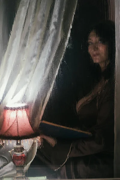 Hermosa Mujer Con Libro Bajo Luz Una Lámpara Detrás Vaso —  Fotos de Stock