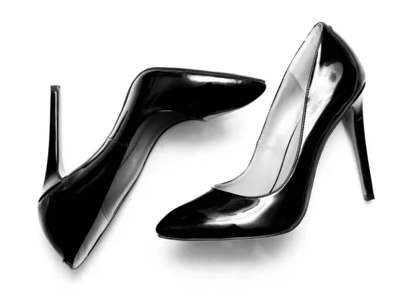 白色背景上漂亮的女性闪亮的黑色高跟鞋 — 图库照片