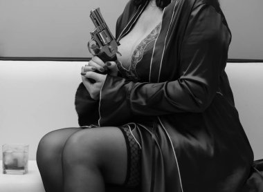 Peignoir 'de elinde tabancayla baştan çıkarıcı bir kadın.