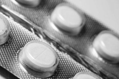 Parlak ambalajda beyaz haplar. Yakın çekim.