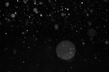 Gece gökyüzünün siyah arka planında güzel, uçan, ağır kar.