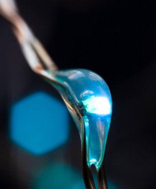 Siyah bir arka planda küçük, parlak mavi bir lamba.