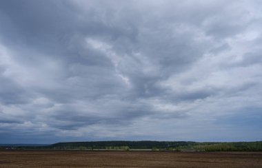 Pürüzlü tarlalar ve baharda bulutlu gökyüzü