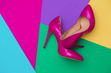 Güzel kadınların parlak patentli mor topukluları renkli arka planda. 