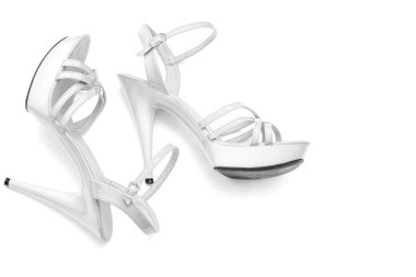 Güzel kadınların parlak patentli beyaz topuklu sandaletleri beyaz arka planda.