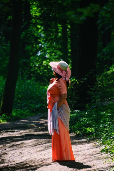Красивая Взрослая Женщина Длинном Коралловом Платье Широкая Шляпа Прогулки Летнем — стоковое фото
