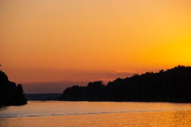 Yazın nehirde güzel turuncu gün batımı 