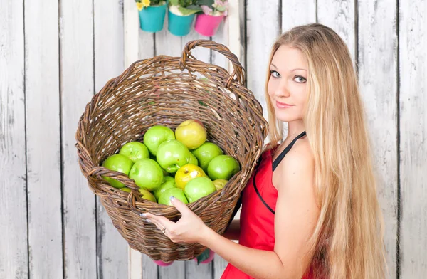 Woman with a basket of apples — Stock Photo, Image