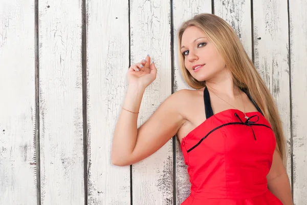 Woman against a white fence — Stock Photo, Image