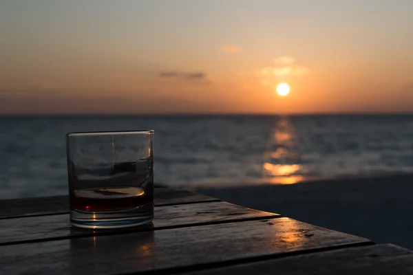 Bebida al atardecer en la playa Imagen de archivo