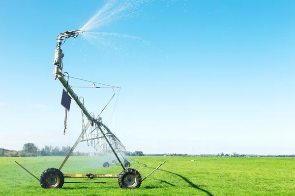 Spraya vatten maskinen i gräsmark — Stockfoto
