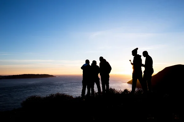 Mensen op de oever van de zee met sunrise sky — Stockfoto