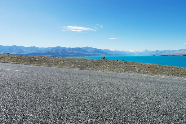 Ασφαλτοστρωμένο δρόμο κοντά στη λίμνη στη Νέα Ζηλανδία — Φωτογραφία Αρχείου
