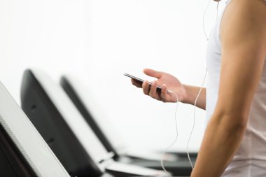 akıllı telefon kullanan modern spor salonunda Asyalı adam