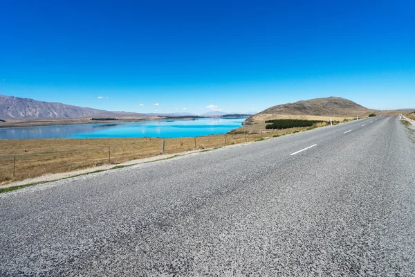 Asfaltová silnice poblíž jezero na Novém Zélandu — Stock fotografie