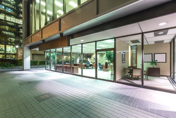 Edifício de escritórios moderno e caminho pedestre à noite — Fotografia de Stock