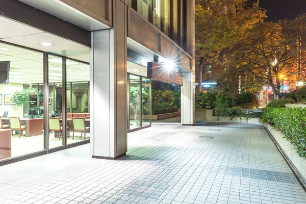 Modern office building and footpath at night — Stock Photo, Image