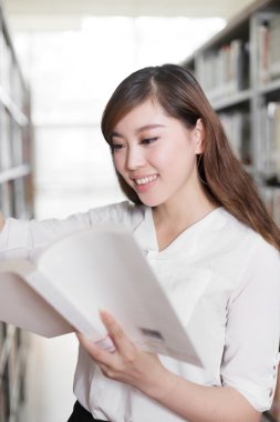 Asyalı kız öğrenci modern Kütüphane kitap ile
