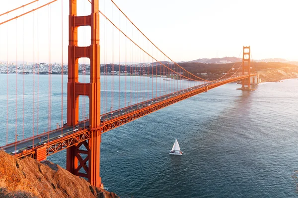 Gold Gate Bridge and sailboat on sea in sunny day — Stock Photo, Image