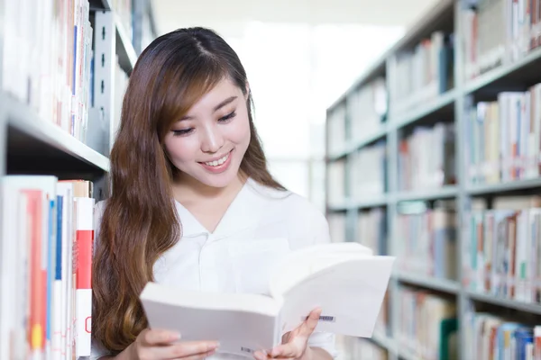 Asijská studentka s knihou v moderní knihovna — Stock fotografie