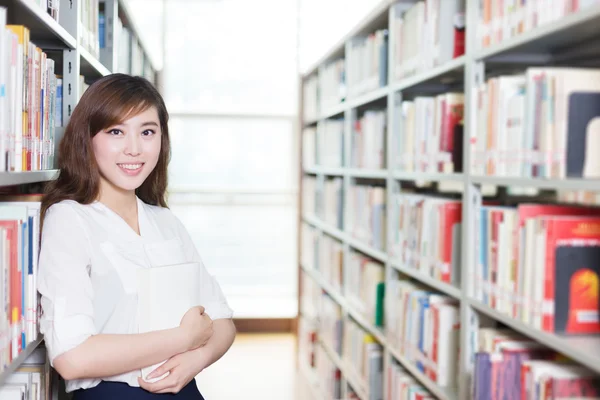 Азиатская студентка с книгой в современной библиотеке — стоковое фото