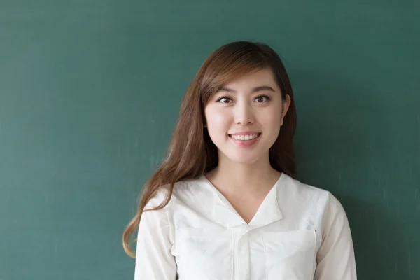 Beautiful girl teacher with green blackboard — Stock Photo, Image