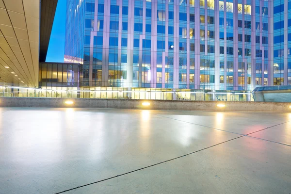 Empty floor and modern buildings at night — Stock Photo, Image