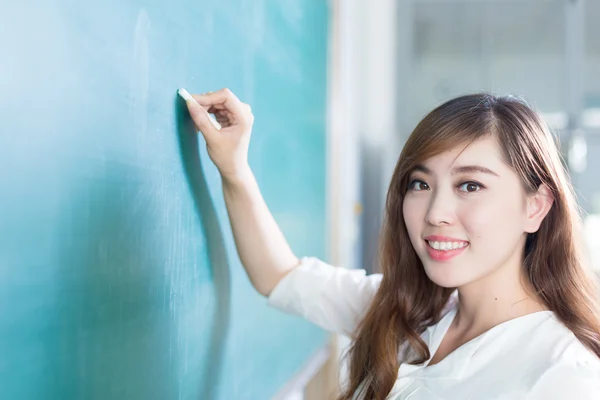 Mädchen mit grüner Tafel im Klassenzimmer — Stockfoto