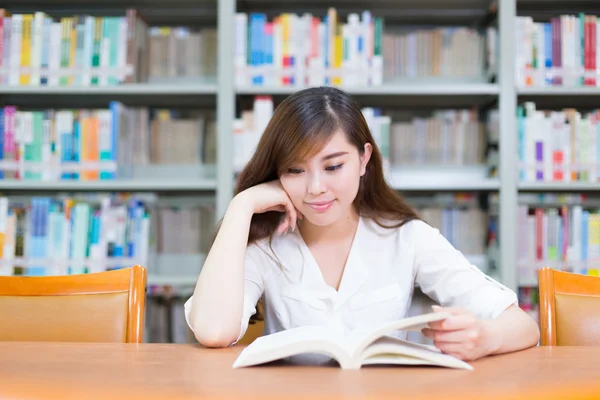 Meisje leesboek in de schoolbibliotheek — Stockfoto