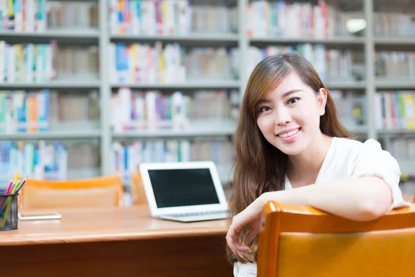 Asiatische Mädchen mit Laptop in der Schulbibliothek — Stockfoto