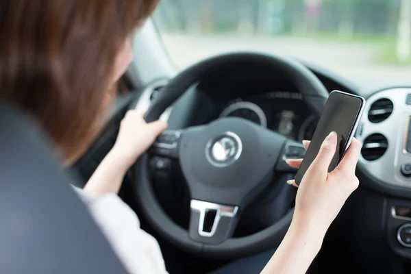 Junge asiatische Mädchen mit Telefon im Auto — Stockfoto