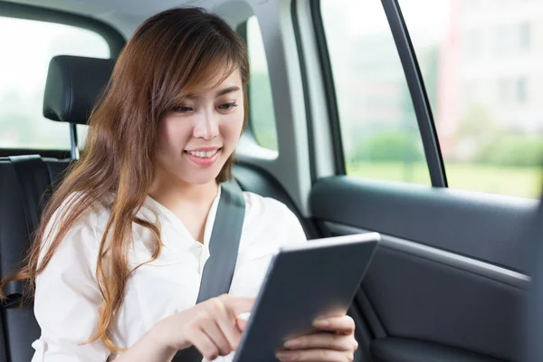 Jovem asiático menina com tablet no carro — Fotografia de Stock