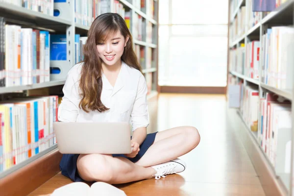 Student vysoké školy dívka s notebookem v knihovně — Stock fotografie