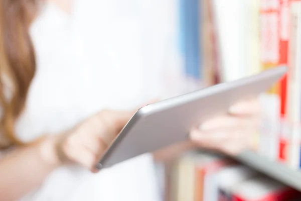 Meisje universitaire student met tablet in bibliotheek — Stockfoto