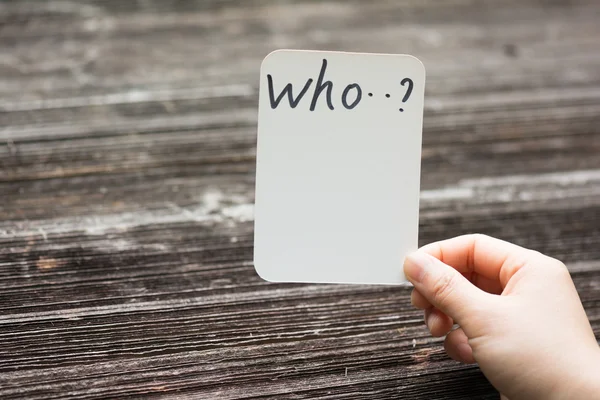 Person holds card with text who...? — Stock Photo, Image