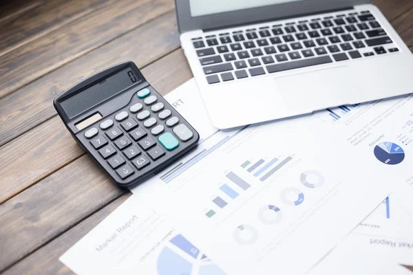 Laptop en calculator op financieel verslag — Stockfoto