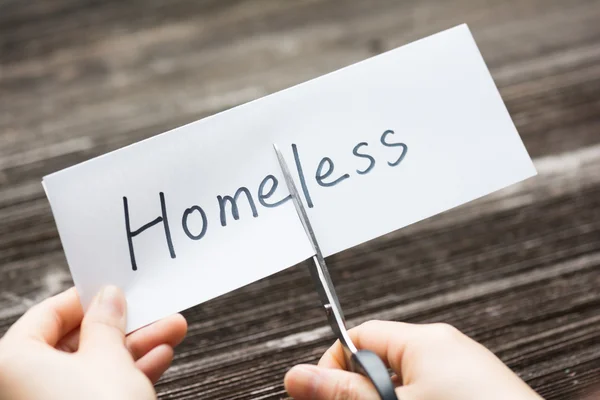 Person hält Karte mit Text Obdachlos — Stockfoto