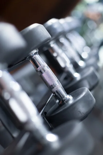 Dumbbells in modern gym in row — Stock Photo, Image