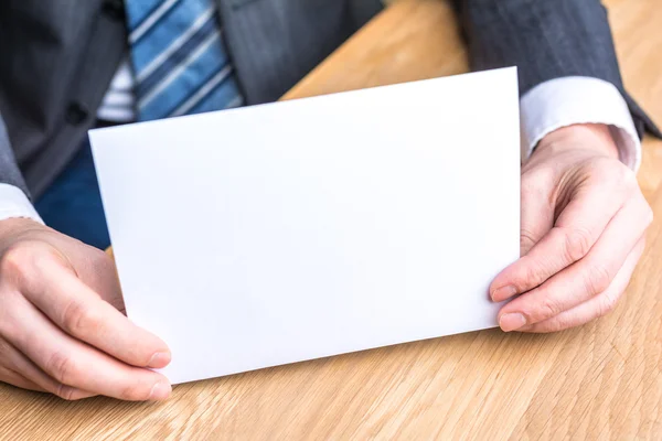Mão de homem de negócios e papel branco em branco — Fotografia de Stock