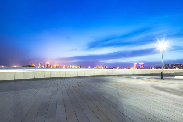 Pavimento con paesaggio urbano e skyline di Harbin di notte — Foto Stock