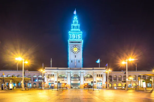 Tower building with monument and clock at night — Stock Photo, Image